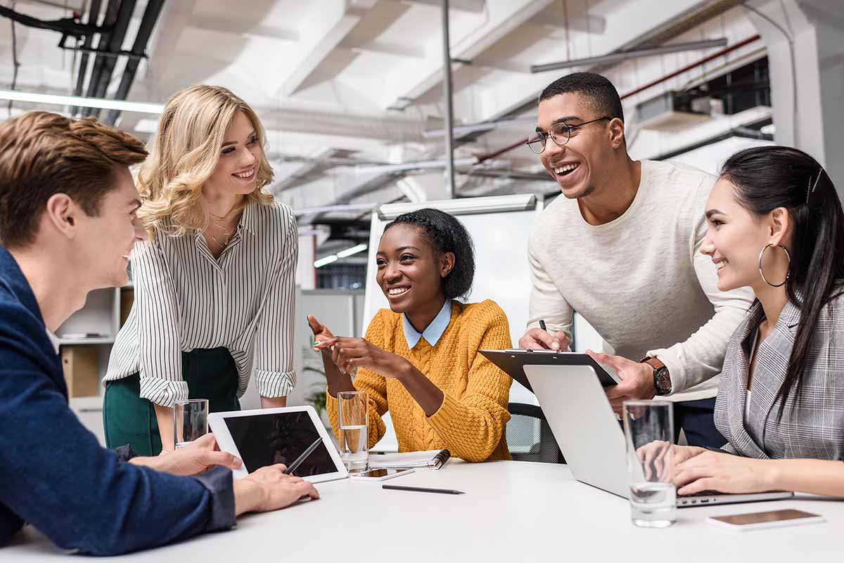 A group of smiling young colleagues having a meeting.