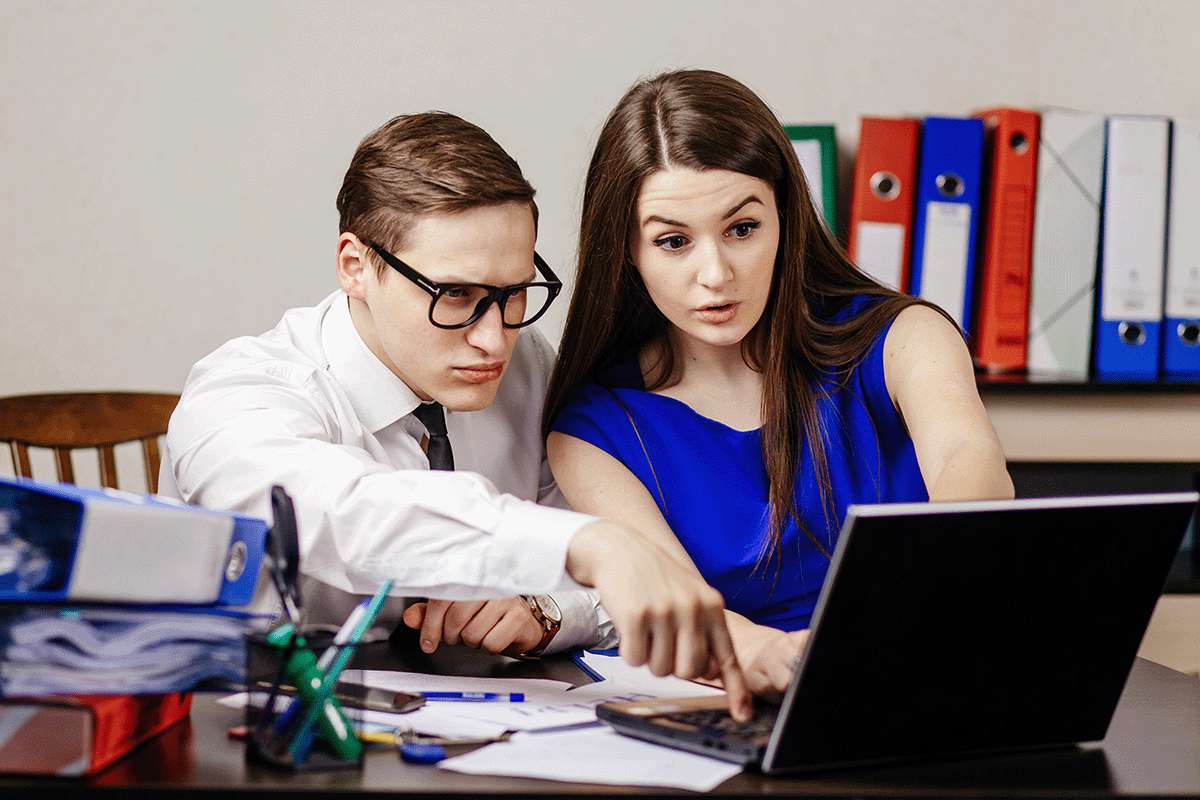 Business coworkers looking at a laptop