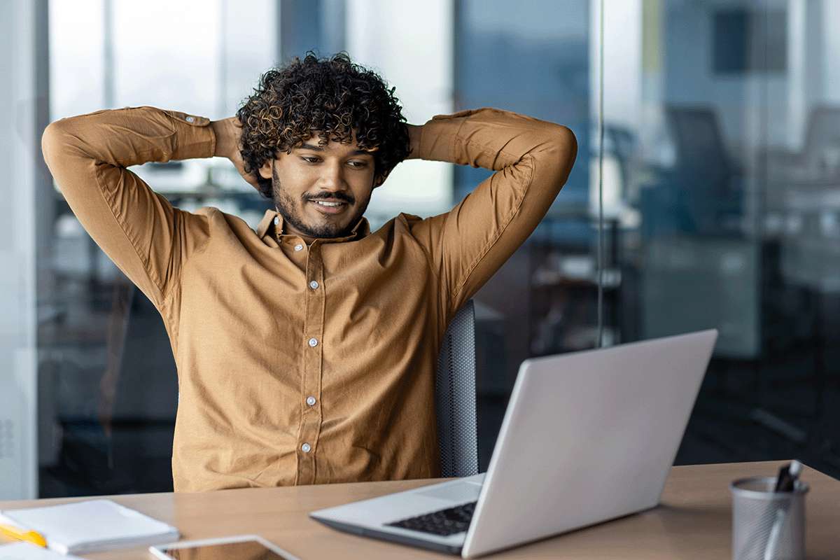 A young man looking at an open laptop